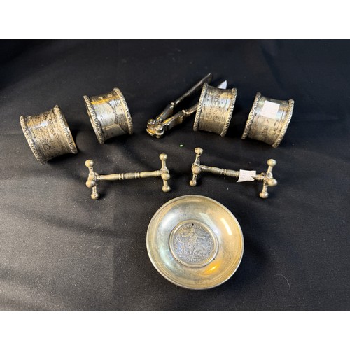 556 - A small circular white metal dish with inset coin / medallion, unmarked; a pair of nutcrackers; a pa... 