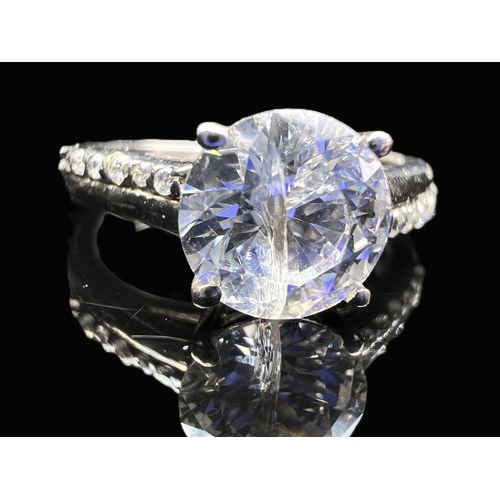 A modern silver ring set with multi coloured stones in rub over setting ...