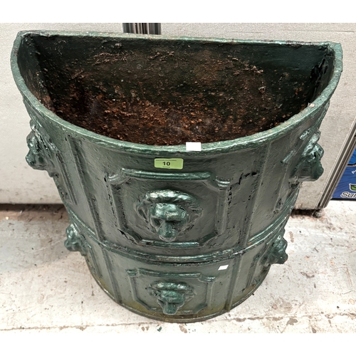 10 - A pair of green painted demi-lune cast iron troughs with lion mask decoration, diameter 55cm.