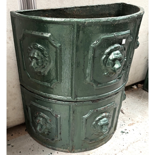 10A - A pair of green painted demi-lune cast iron troughs with lion mask decoration, diameter 55cm.