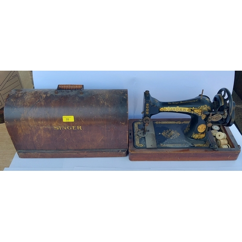 35 - A vintage early 20th century singer hand crank sewing machine with distinctive gingerbread pattern a... 