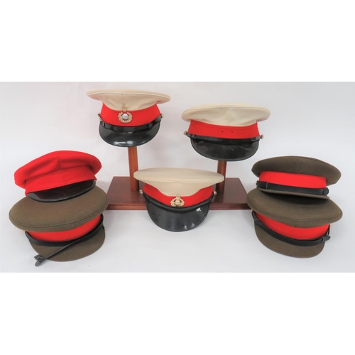 Three Post War Royal Marines Dress Caps
white composite crown and body.  Black peak and chinstrap.  Two complete with anodised, QC Royal Marine badges.  Together with 3 x khaki service dress caps with red bands ... Red dress cap with black peak.  7 items.