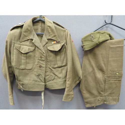1937 Pattern REME Officer's Battledress Jacket, Trousers and FS Cap
khaki woollen, single breasted, converted open collar, short jacket.  Lower belt with plated buckle.  Pleated chest pockets with hidden button flaps.  Shoulder straps with embroidery, dark blue backed, Captain's rank stars.  Both arms with embroidery REME titles over coloured felt, arm of service bars.  Internal label absent.  Matching khaki woollen, wide leg trousers.  Right hip, open top, first aid pocket.  Left front leg with large pocket.  Top flap secured by exposed button ... Officer's, khaki field service cap.  Two front bronzed REME buttons.  Bronzed KC REME cap badge.  Jacket and trousers named "Lt R A Rowland".  Minor moth nips.  3 items.