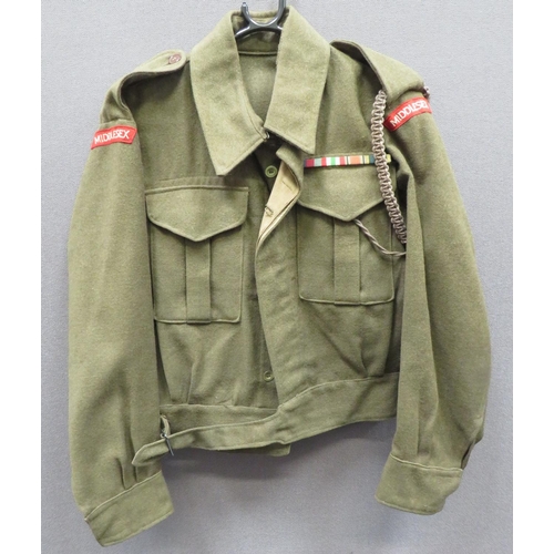 1937 Pattern Australian Made Middlesex Regiment Battledress Jacket
khaki green woollen, single breasted, closed collar, short jacket.  Lower belt secured by blackened steel buckle.  Pleated chest pockets with hidden button flaps.  Both arms with embroidery Middlesex titles.  Left chest with WW2 medal ribbons.  Internal issue label "Made In Australia 1943".  Clean condition.