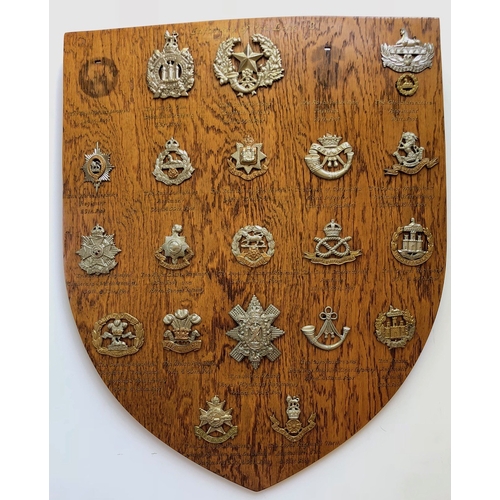 105 - 21 Infantry cap badges mounted on shield.   Good selection beautifully mounted on varnished wooden s... 