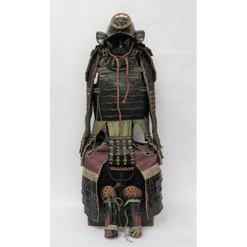 Full Suit Of Japanese "Edo" Period Samurai Armour 
consisting black lacquered, Kabuto helmet.  Crinkle lacquer central ridge.  Front wings and detachable, central, brass mon.  Four tier lacquered neck guard (hineno-jikord) with green lacing ... Black lacquered (mempo) face guard with two tier neck guard ... Lacquered breast and back plates ... Matching shoulder (side) panels ... Leg and thigh (Haidate and Kasazuri) panels ... Silk backed arm and hand (kote and tekko) panels with chain mail joining the small armoured sections.  All joined with green cord and horn toggles.  Armour contained in its black painted, wooden transit case with steel carrying handles.  Minor damage to helmet lacquer.  