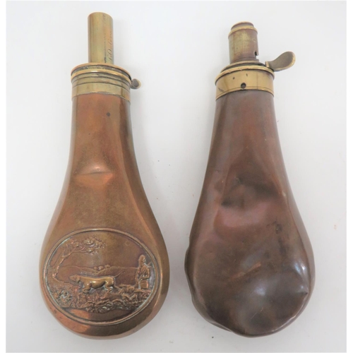 Two Copper and Brass Powder Flasks
consisting copper body with lower shooter and dog cartouche to both sides.  Brass top with hidden spring (absent).  Plain nozzle marked "60 GRS".  Together with a plain copper bodied example.  Brass top marked "Foster Sheffield".  Adjustable nozzle.  Spring absent.  Some dents to both.  2 items.