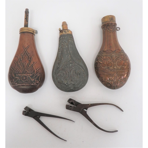 Small Selection of Flasks and Bullet Moulds
consisting copper, floral scroll example.  Brass top ring.  Top absent ... Well made, Pedersoli, Colt style flask.  The copper body with stand of arms to one side.  Brass top with long extendable nozzle ... Tin body flask with scroll floral design.  Brass top with exposed spring.  Plain nozzle ... 2 x steel pincer ball moulds marked 18 & 72.  5 items.  