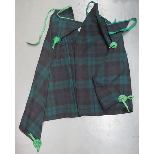 Two Scottish Shoulder Plaids
tartan woollen triangular plaid.  One lower corner with a green rosette.  Green cord attached smaller tartan triangle with single green rosette.  Minor service wear.  2 items.