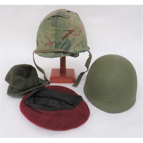 Vietnam Period American Steel Helmet
green painted steel helmet.  Swivel side bales.  Inner fibre helmet with webbing and leather liner.  Complete with camouflaged outer cover.  Together with a spare fibre inner helmet with webbing and leather liner ... American style woollen cap ... Post war British maroon beret.  