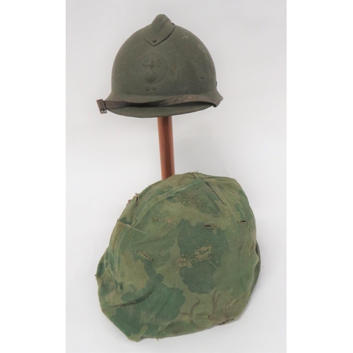 French Infantry M26 Steel Helmet
green painted crown and brim with top comb.  Front Infantry pattern circular badge.  Black treated linen, six tongue liner.  Leather chinstrap.  Together with an American pattern front seam brim helmet.  Double sided, camouflaged cover.  Complete with inner fibre helmet with webbing head harness.  2 items.
