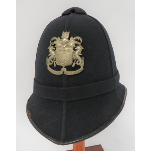 Cambridge Borough Police Helmet
black melton, six panel crown.  Pointed peak and rounded rear brim, all with black patent leather edging.  Crown with matching black melton button.  White metal Cambridge Borough Police helmet plate.  Leather sweatband.  Some service wear. 