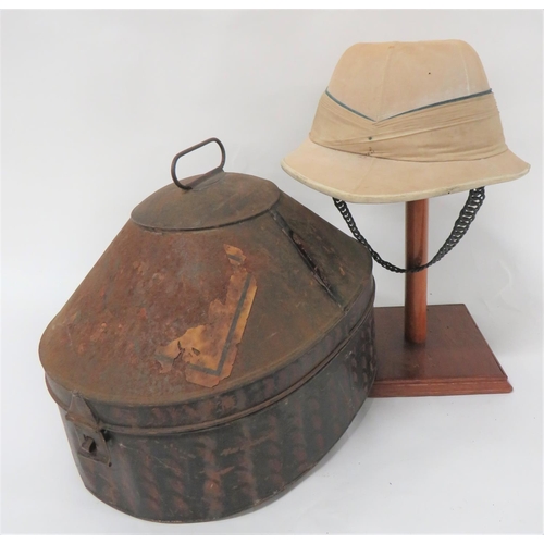 Early 20th Century Officer's Tropical Pith Helmet Possibly Indian Regiment
cream khaki, six panel crown.   Pointed peak and rounded rear brim with leather edging.  Linen, multi fold pagri band with grey top fold.  Inner green lined brim (some moth).  Leather sweatband with "Bombay" maker.  Crown with "Hawkes & Co" maker's stamp.  Brass chin chain (backing absent).  Top crown button absent.  Contained in its japanned tin transit box.  