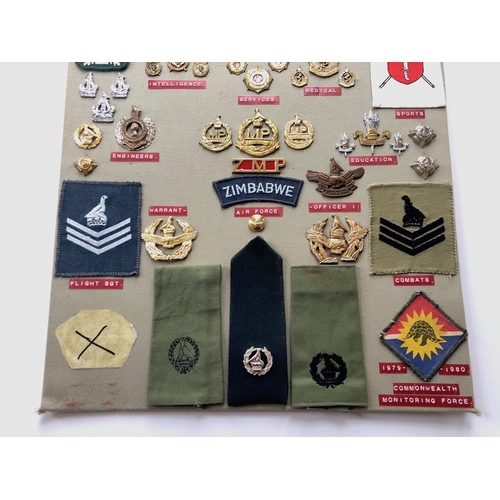 158 - Zimbabwe Army 55 items of insignia post 1980.  Board with good tabulated display of metal and cloth ... 