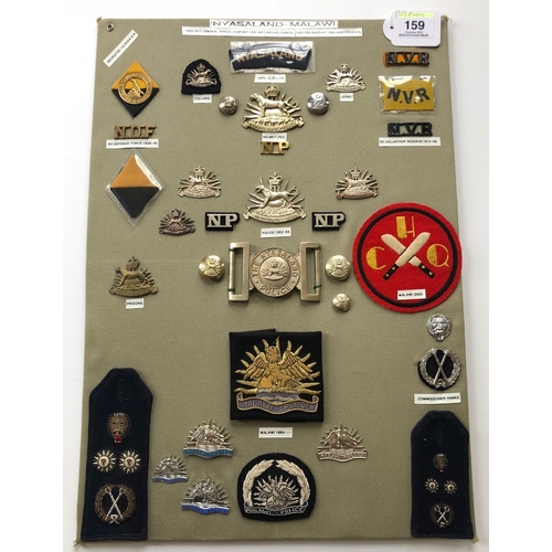 159 - Nyasaland and Malawi Military And Police 36 items of insignia.  Board with good tabulated display of... 