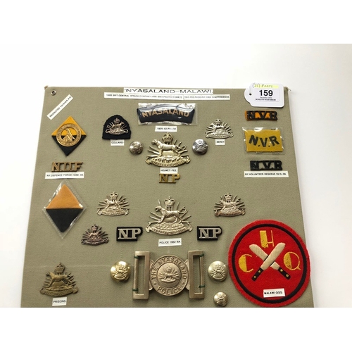 159 - Nyasaland and Malawi Military And Police 36 items of insignia.  Board with good tabulated display of... 