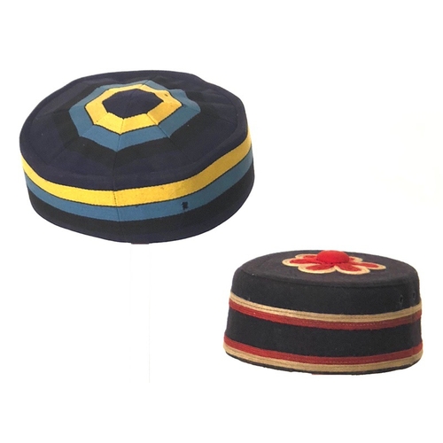2 Victorian / Edwardian Military Pattern Pill Box Caps  Two examples the first of dark blue cloth with yellow and light blue decoration. The interior with a tailors label of J.G. Plumb & Son Westminster.     Accompanied by a second example of Other Rank junior NCO quality. Dark blue with red and white mohair cord decoration. (2 items)