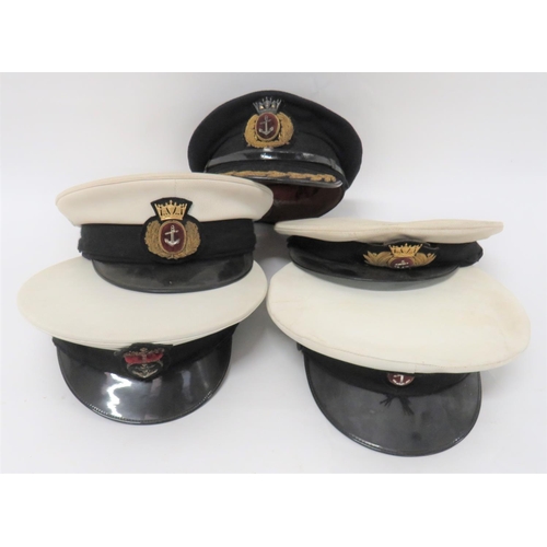 Four Merchant Navy Officer Caps
consisting dark blue example.  The peak with gilt embroidery oak leaf band.  Bullion embroidery cap badge ... 2 x white composite crown examples.  Black composite peaks.  Bullion embroidery cap badge ... Similar example with Petty Officer's Merchant Navy badge ... Similar example with QC Royal Navy Petty Officer's badge.  5 items.