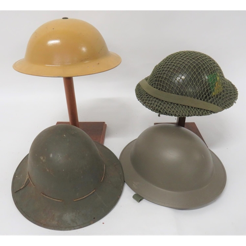 309 - Four British Steel Helmets
consisting khaki yellow, repainted, MKII helmet.  Side brim drilled with ... 