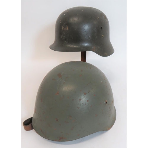 316 - Two Spanish Steel Helmets
consisting M1942, green painted, raw edge crown.  Badge loops to the ... 