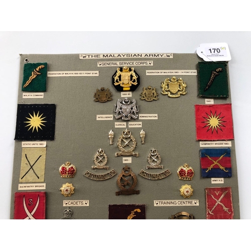 170 - Malaysian Army 49 items of insignia.  Board with good display of metal and cloth badges including tw... 
