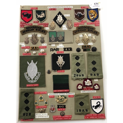 Rhodesian African Rifles and Defence Regiment 47 items of insignia.  Board with good display of metal and cloth badges and buttons including silver examples. Most complete with fixings.        Bob Betts Collection