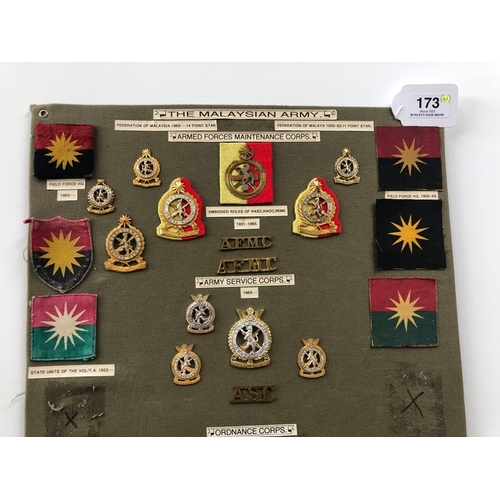 173 - Malaysian Army 41 items of insignia.  Board with good display of metal and cloth badges and buttons ... 