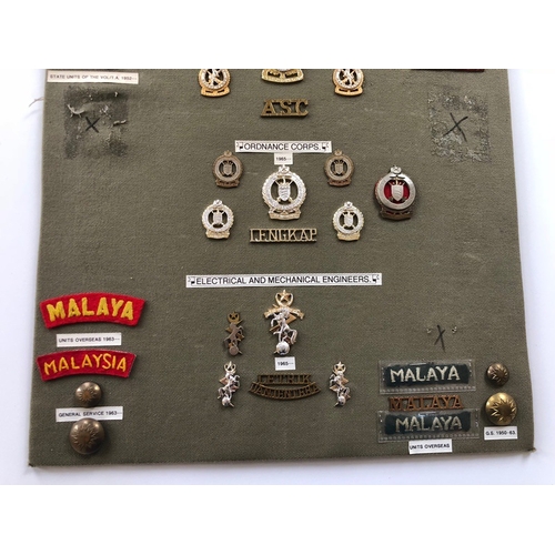173 - Malaysian Army 41 items of insignia.  Board with good display of metal and cloth badges and buttons ... 