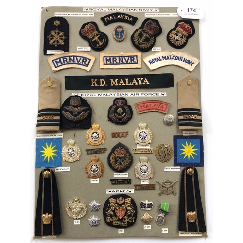 174 - Royal Malaysian Army, Navy and Air Force 40 items of insignia.  Board with good display of metal and... 