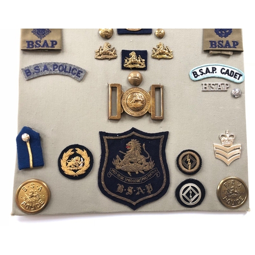 184 - British South African Police 37 items of insignia.  Board with good display of metal and cloth badge... 