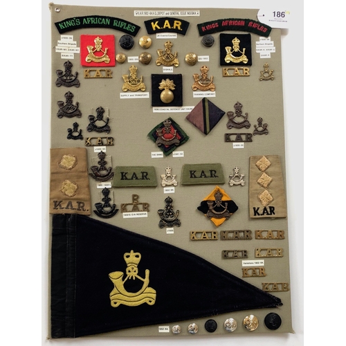 Kings African Rifles 53 items of insignia.  Board with good display of metal and cloth badges and buttons including Training Company, Supply & Transport, Signals etc plus a pennant. Most complete with fixings.        Bob Betts Collection