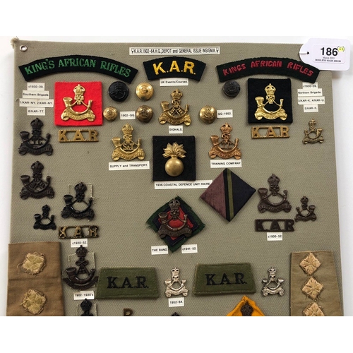 186 - Kings African Rifles 53 items of insignia.  Board with good display of metal and cloth badges and bu... 