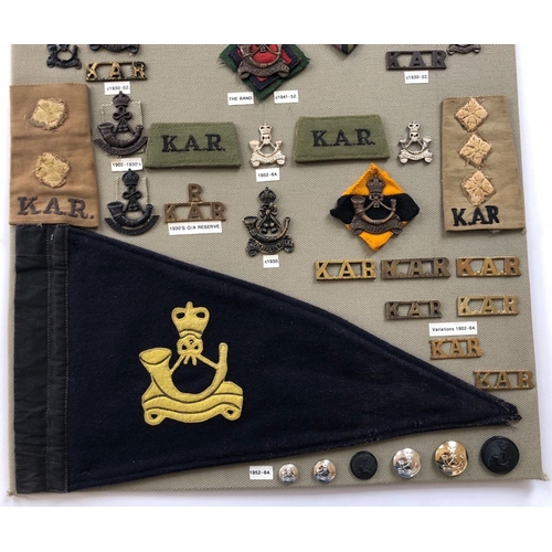 186 - Kings African Rifles 53 items of insignia.  Board with good display of metal and cloth badges and bu... 