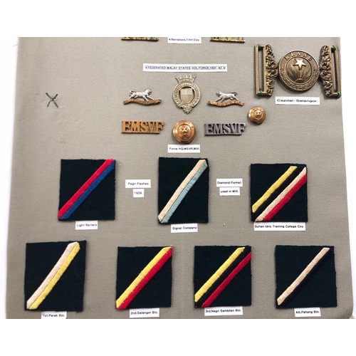 191 - Federated Malay States Volunteer Units 39 items of insignia.  Board with good display of metal and c... 