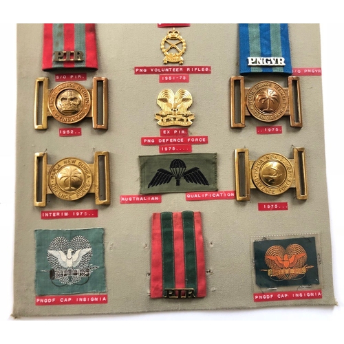 195 - Papua New Guinea 19 items of insignia.  Board with good display of metal and cloth badges including ... 