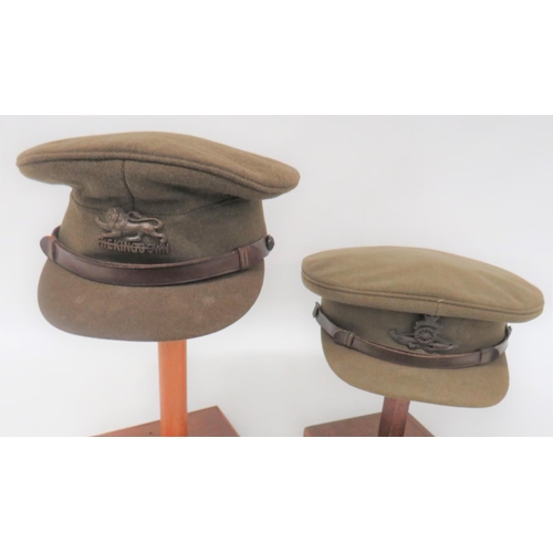 Two WW2 Officer Service Dress Caps
consisting khaki crown, body and stiff covered peak.  Brown leather chinstrap secured by bronzed buttons.  Internal leather sweatband.  One cap with bronzed The Kings Own badge.  The other with bronzed, KC Royal Artillery badge.  2 items.