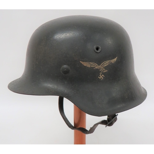 German M1942 Luftwaffe Steel Helmet
dark grey painted shell with lower raw edge.  The left side with 80% transfer of eagle and swastika.  Interior brim stamped "ET66" and "2425".  Steel lining band with built in chinstrap loops.  Nine tongue leather sweatband.  Brown leather chinstrap with steel buckle.  Clean example.  