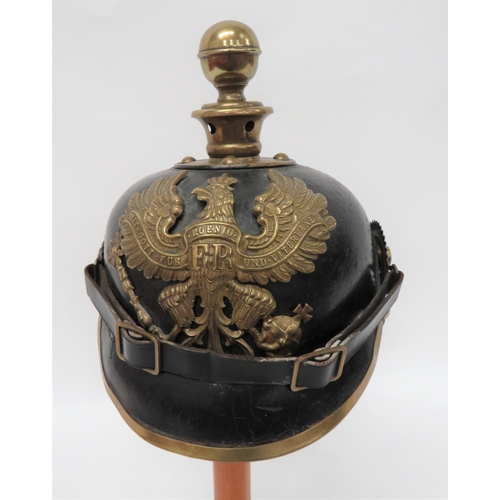 Imperial German Prussian Artillery Pickelhaube 
black leather crown, attached peak with brass edging.  Attached rear brim with brass spine mount.  Circular brass crown mount with ball top fixing.  Brass Prussian eagle helmet plate.  Coloured side cockades replaced holding the replaced leather chinstrap.  Internal, nine tongue leather liner.  Helmet with some old restoration. 