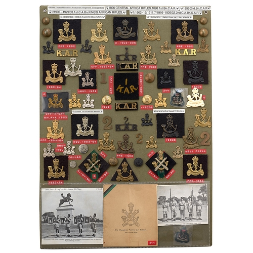 390 - 62 King's African Rifles badges etc.  Board with good display of metal and cloth badges, buttons etc... 