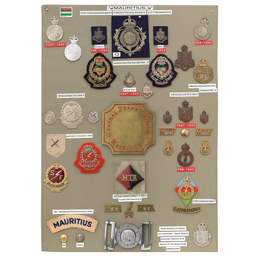 402 - 38 Mauritius military and police badges etc.  Board with good display of metal and cloth badges, a w... 