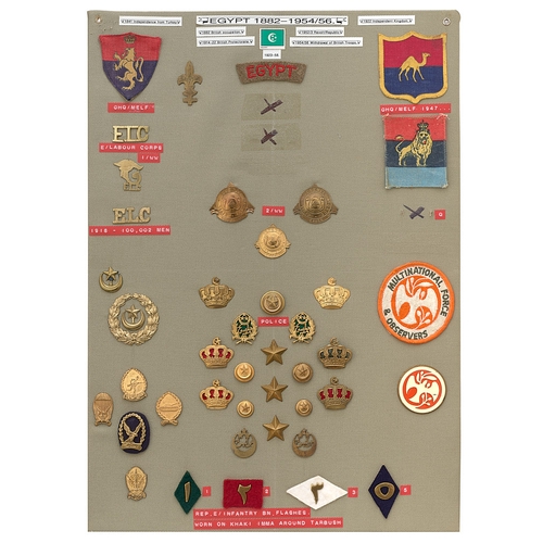 403 - 42 Egypt military and police badges etc.  Board with good display of metal and cloth badges, buttons... 