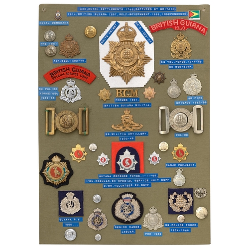 405 - 39 British Guiana military and police badges etc.  Board with good display of metal and cloth badges... 