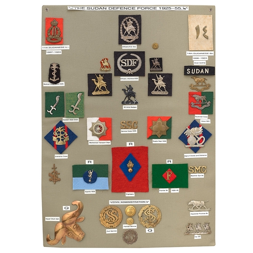 407 - 34 Sudan Defence Force badges etc.  Board with good display of metal and cloth badges including HM s... 