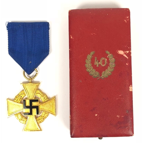German Third Reich cased Faithful Service Decoration 1st Class for 40 years by Deschler & Söhne, München.  A fine gilt example with black enamel swastika on cornflower blue ribbon housed in red fitted case of issue, the lid with gold embossed 40 within laurel sprays. VGC (minor scuffs to case)        Following the first mention of such awards in late 1935, the Faithful Service Decorations were instituted by Adolf Hitler on 30th January 1938, designed by Professor Richard Klein
