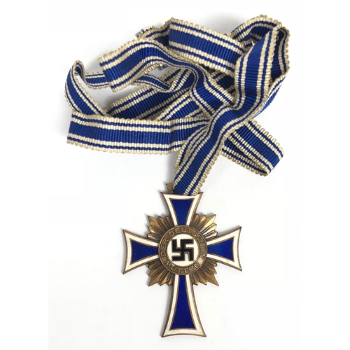 German Third Reich. 3rd class Cross of Honour of the German Mother.  A good bronzed example awarded for bearing 4 or 5 children. Blue and white enamelled arms and central black enamel swastika complete with length of neck ribbon.  Reverse with facsimile Adolf Hitler signature. VGC        Instituted by Adolf Hitler on 16th December 1938.