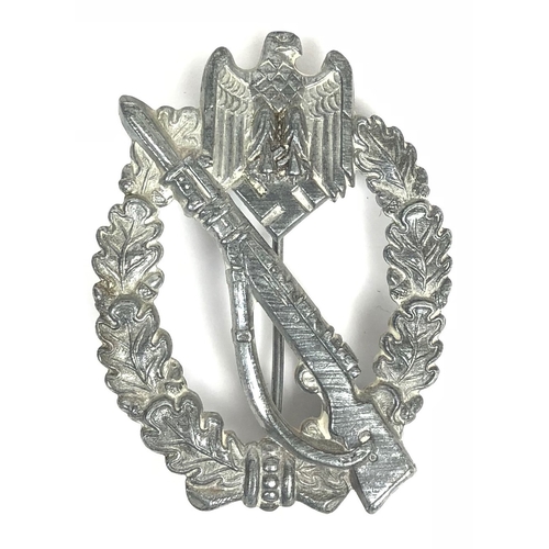 German Third Reich WW2 Army / Waffen-SS Infantry Assault badge.  A good die-stamped silvered issue. Rifle with fixed bayonet superimposed on oval oak wreath surmounted by eagle and swastika. Vertical round pin with securing hook, both attached by criping. VGC        Designed by Junker of Berlin and instituted 20th December 1939.