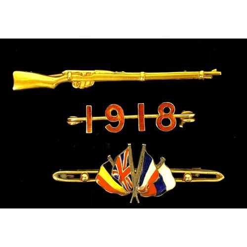 WW1 Gold Patriotic Brooches. 3 Examples. Comprising: Gold rifle embossed 9CT Length 6cm. ... Gold coloured metal bar brooch with 1918 in red enamel Length 36mm. ... United We Stand Allied Flags, this appears to be enamel flags on silver set onto a 9ct gold bar. All complete with pin fittings. (3 items)