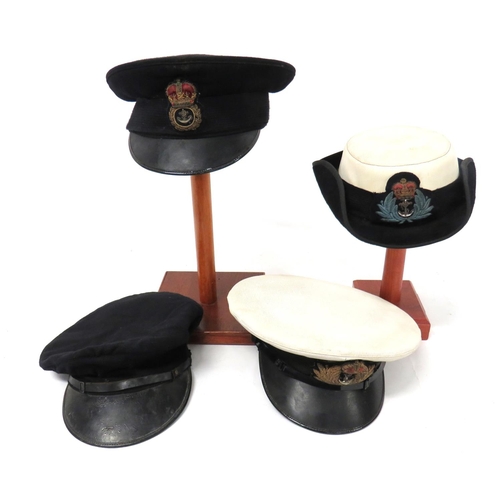 Four Royal Navy Caps
consisting dark blue, Chief Petty Officer cap.  Bullion embroidery CPO badge ... Similar cap.  No band or badge ... Women's Officer tricorn hat.  White top.  Black body.  Bullion embroidery, QC badge ... RN Officer's cap.  White top.  Black body.  Bullion embroidery KC Officer badge.  4 items.