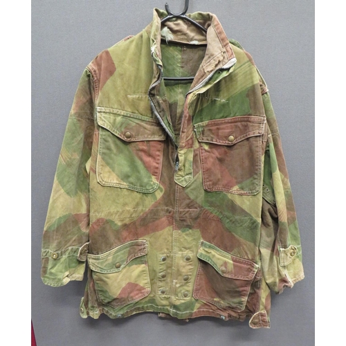 WW2 Pattern Airborne Troops Denison Camouflaged Smock
green, brown and tan, half zip front smock.  Patch chest and lower pockets, all with brass press stud fastened flaps.  Lower crotch strap.  Lower smock tightening straps.  Cuffs with tightening straps.  Two internal, open end pockets.  Internal issue label "Smock Denison Airborne Troops".  Dated 1946.  Zip stiff.  Some service wear. 