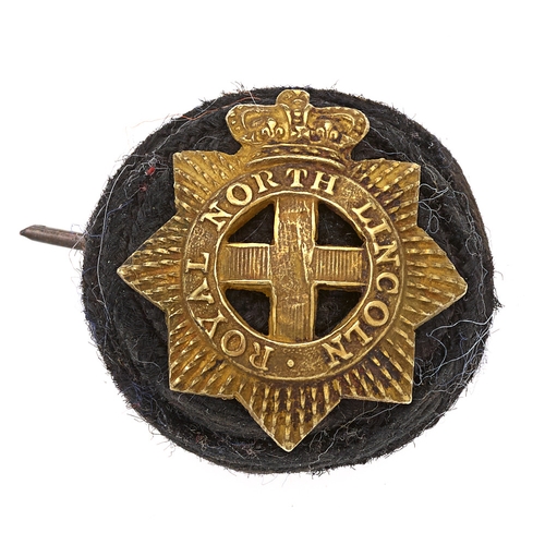 Badge. Royal North Lincoln Militia Victorian Officer's badge on cord boss.  Good scarce black cord boss mounted by gilt crowned star bearing ROYAL NORTH LINCOLN circlet with central cross.    One of two wires.  GC